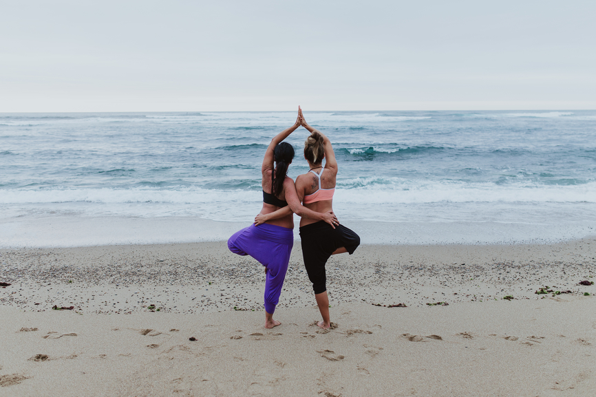 Two women in Yoga twin tree position 