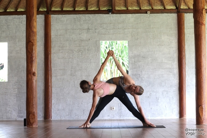 two girls in twisted triangle yoga pose - Yoga Poses For Couples