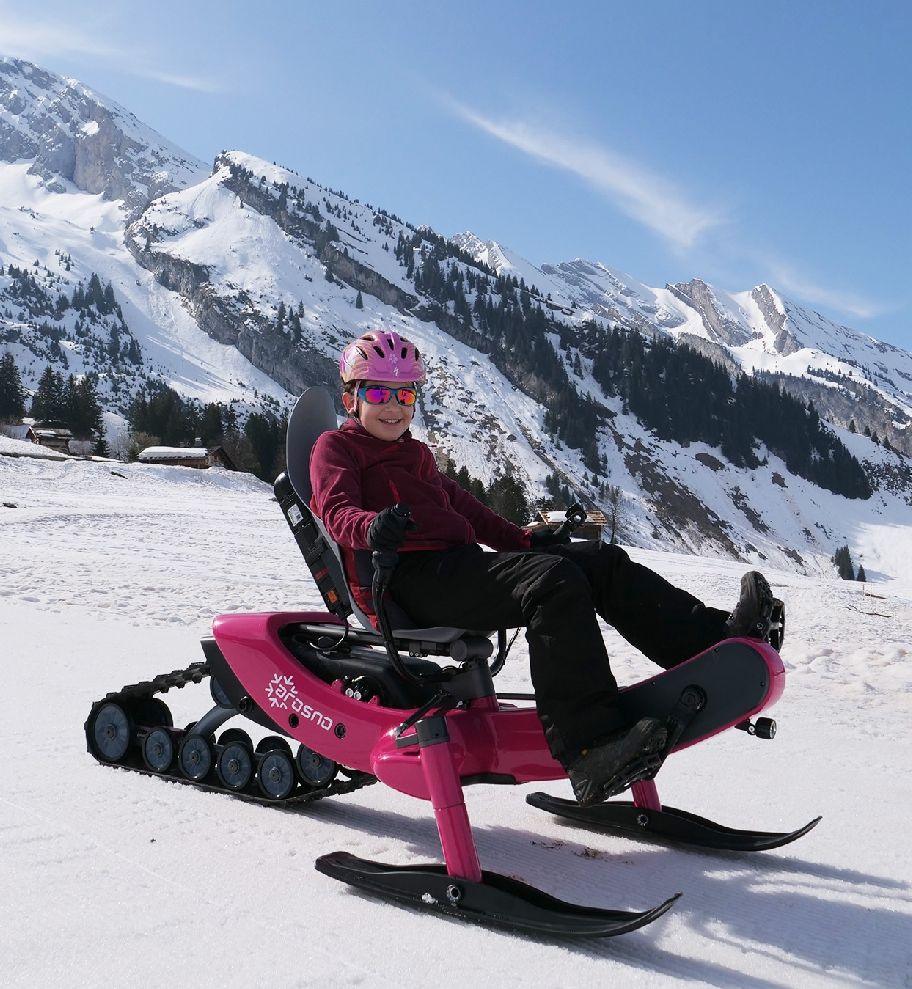 Sledding down slope on Arosno electric snow bike