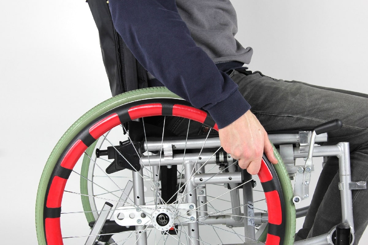 A person with disability using pushing wheel using rim cover