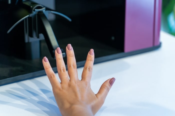 Girl showing fingernails manicured by Clockwork machine