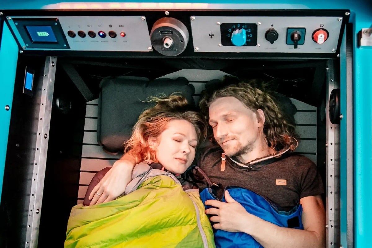 Two people sleeping in amphibious electric camper